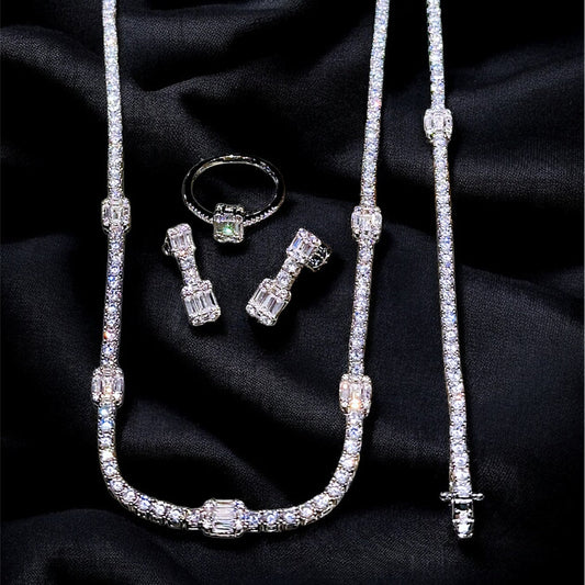 Silver jewelry set including necklace, earrings, and ring on black fabric