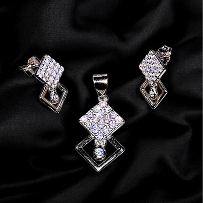 Silver jewelry set with diamond-like stones on a black fabric background