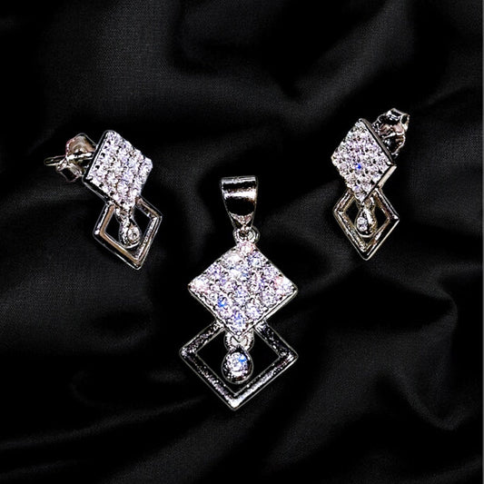 Silver jewelry set with diamond-like stones on a black fabric background
