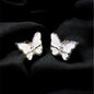 Butterfly-shaped earrings on a black fabric background