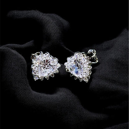 Pair of diamond earrings on a black fabric background