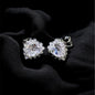Pair of diamond earrings on a black fabric background