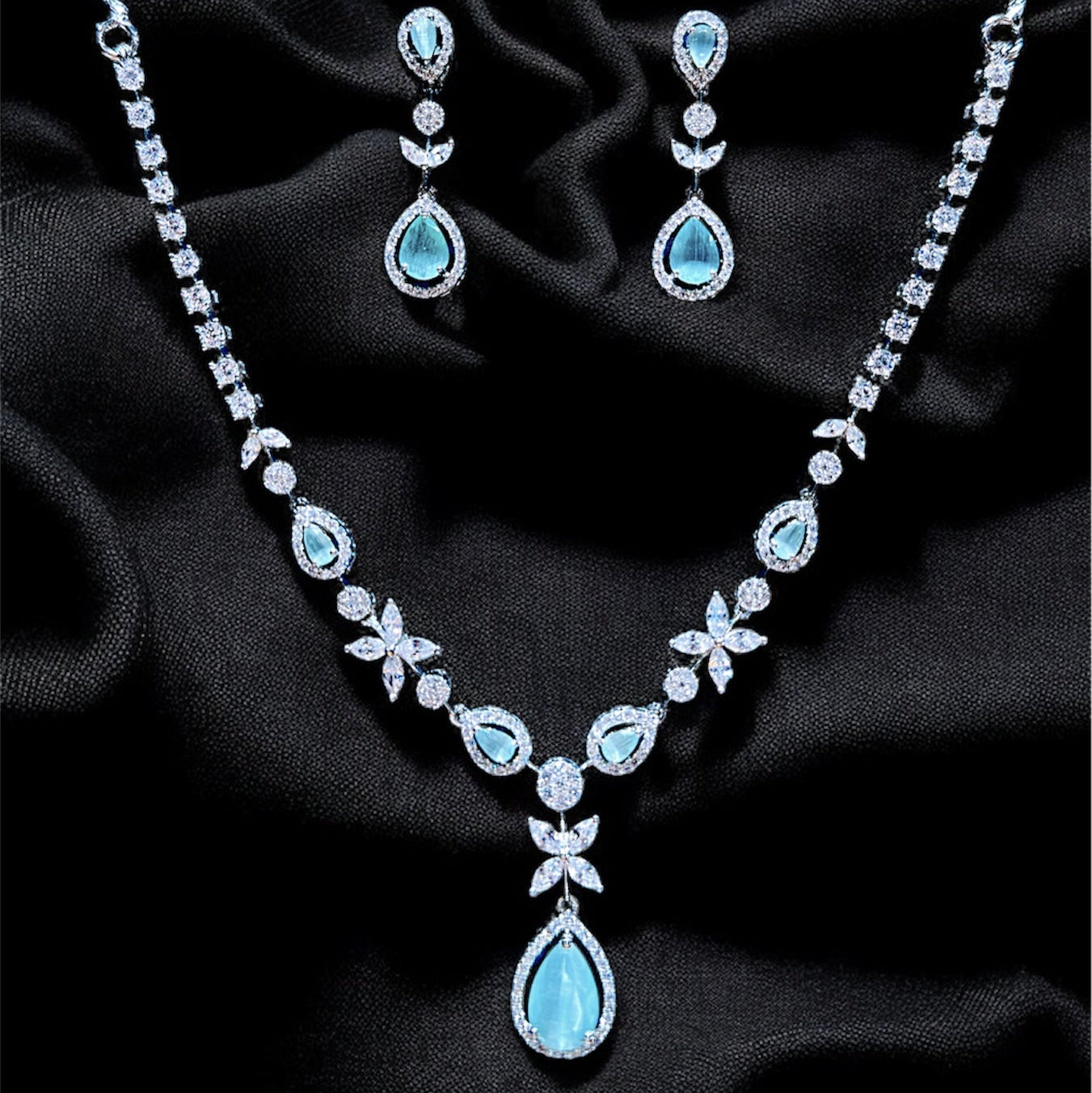 Jewelry set with necklace and earrings on a dark fabric background