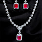 Jewelry set with necklace and earrings featuring red gemstones on a dark background