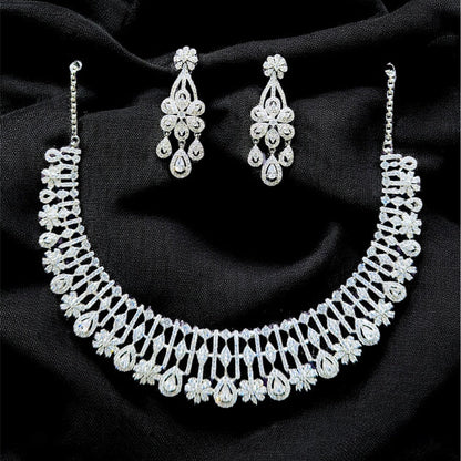 Silver necklace and earrings on a black fabric background