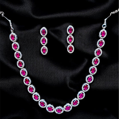 Necklace and earrings with red gemstones on a black satin background