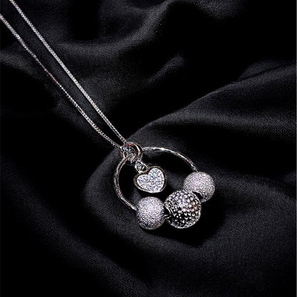 Silver necklace with spherical pendants on a black fabric background