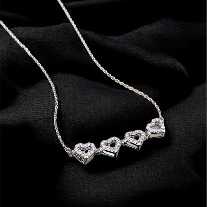 Silver necklace with heart-shaped pendants on a black background