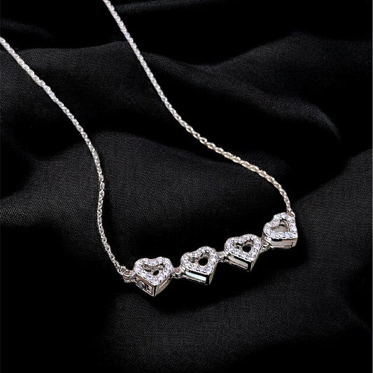 Silver necklace with heart-shaped pendants on a black background
