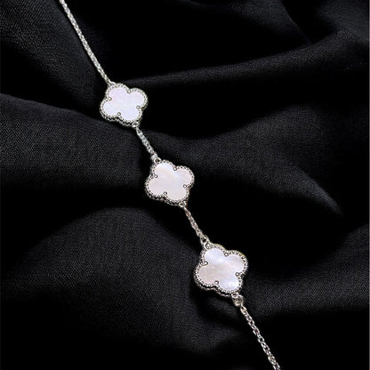 Silver bracelet with floral designs on a black fabric background