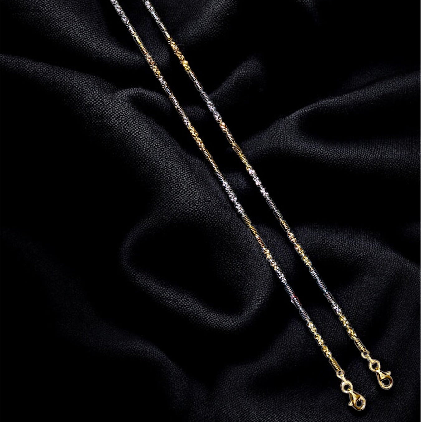 Gold necklace on a black textured fabric background