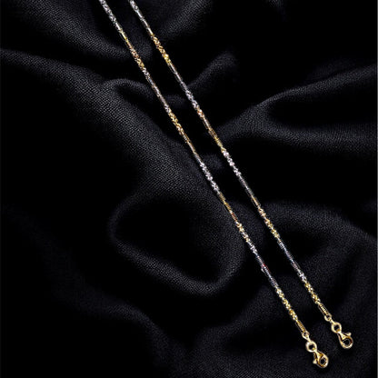 Gold necklace on a black textured fabric background
