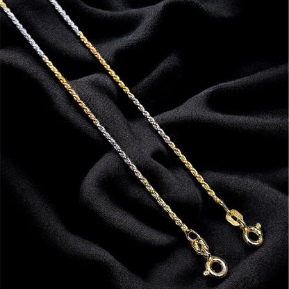 Two gold necklaces on a black fabric background