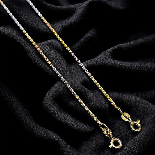 Two gold necklaces on a black fabric background