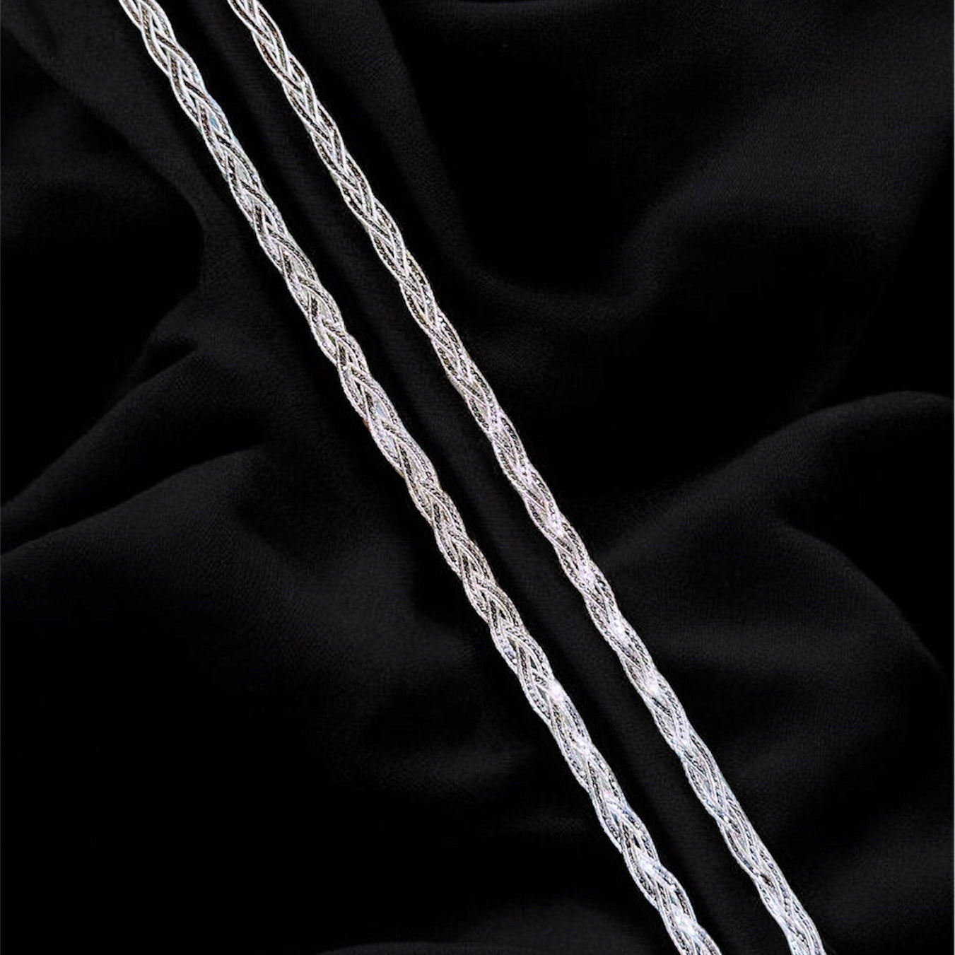 Silver chain on a black fabric background