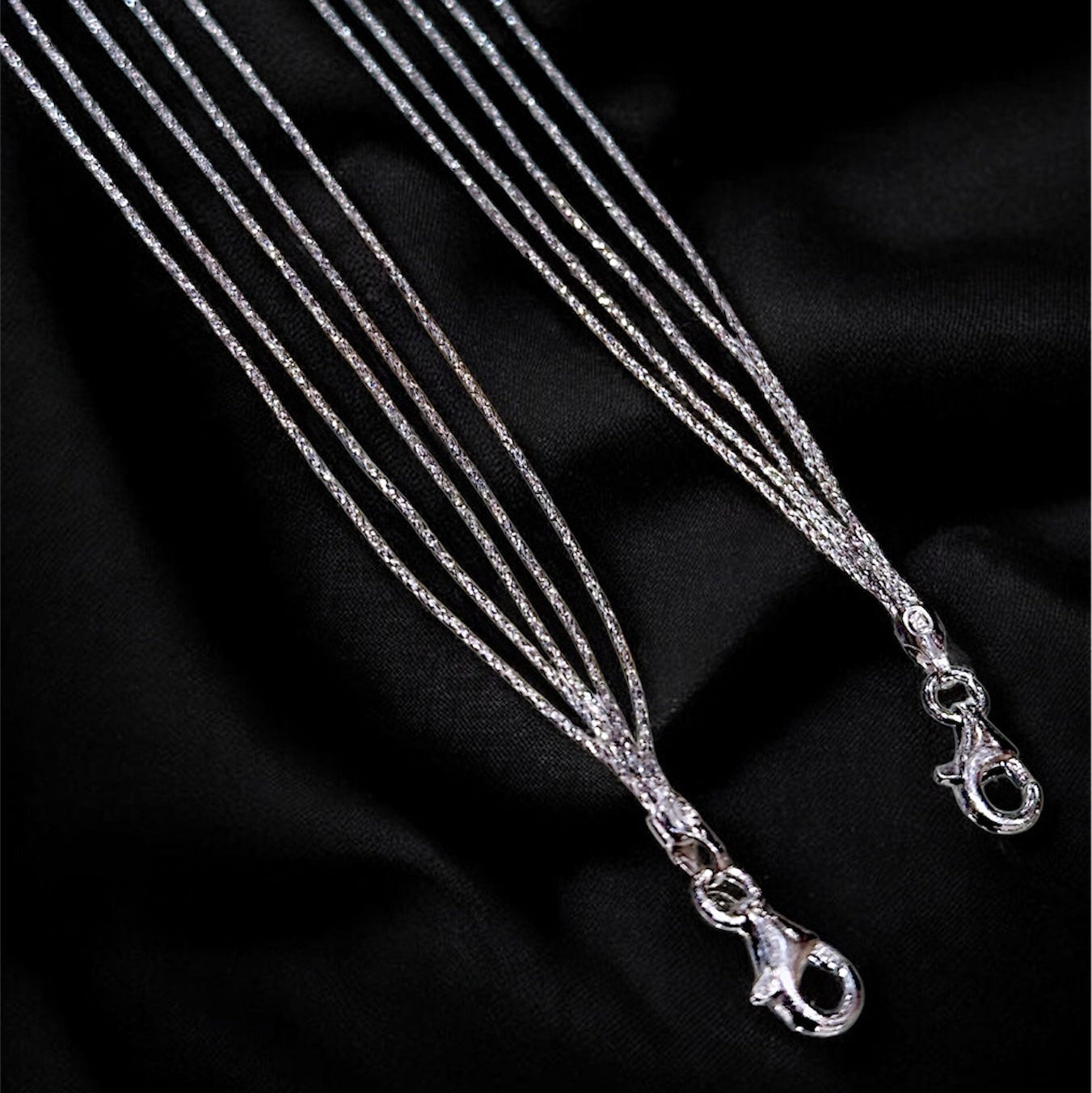 Silver necklace on a black fabric background