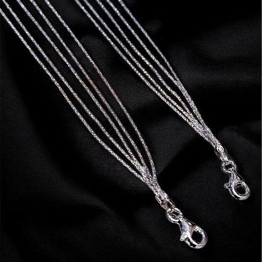 Silver necklace on a black fabric background