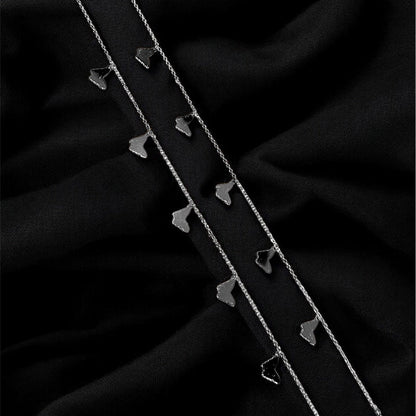 Two silver hairpins on a black fabric background