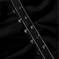 Two silver hairpins on a black fabric background