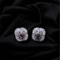 Pair of silver floral earrings on a black fabric background
