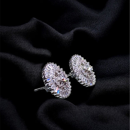 Pair of silver earrings on a black fabric background