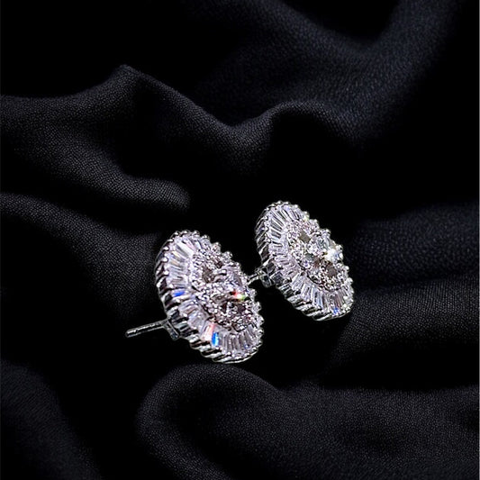 Pair of silver earrings on a black fabric background