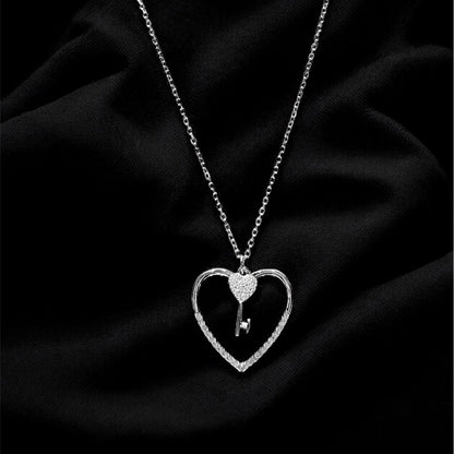 Silver necklace with a heart-shaped pendant on a black fabric background