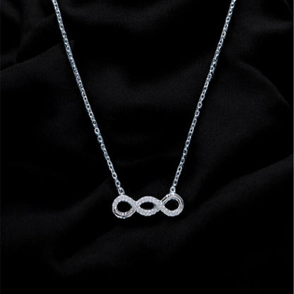 Silver necklace with a unique pendant on a black fabric background