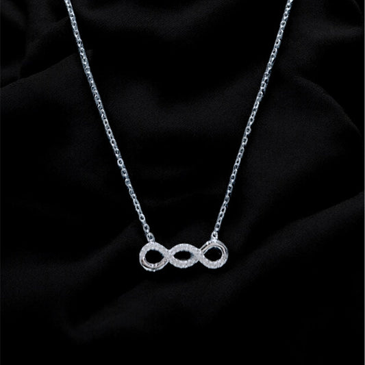 Silver necklace with a unique pendant on a black fabric background