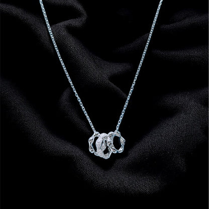 Silver necklace with a pendant on a black fabric background