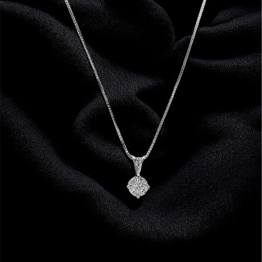 Silver necklace with a pendant on a black fabric background