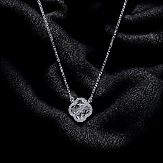 Silver necklace with a pendant on a dark fabric background