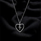Silver necklace with a heart-shaped pendant on a black fabric background