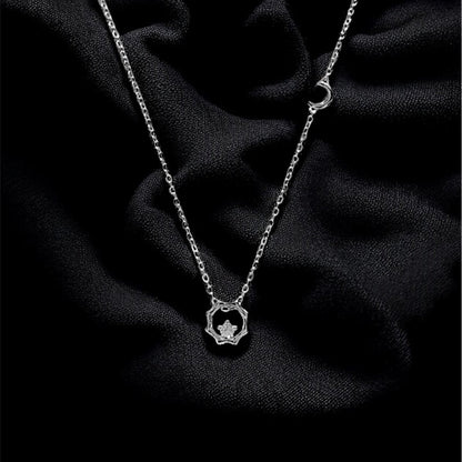 Silver necklace with a heart pendant on a dark fabric background