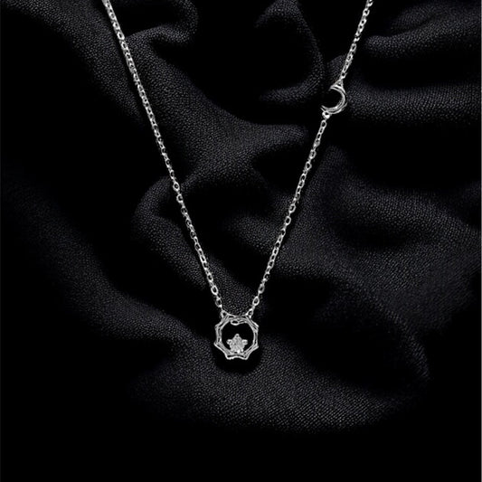 Silver necklace with a heart pendant on a dark fabric background