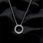 Silver necklace with a circular pendant on black fabric