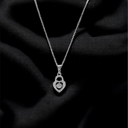 Silver necklace with a heart-shaped pendant on a black fabric background